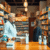 Interior of a cozy independent pharmacy with a friendly pharmacist assisting a customer, shelves filled with medications and health products.