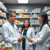 A modern pharmacy with a pharmacist consulting a patient, surrounded by medication shelves and prescription bottles.