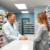 Bright pharmacy interior with a friendly pharmacist consulting a smiling patient over the counter, surrounded by shelves of medicine and health pro...
