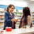 A bright pharmacy counter with a friendly pharmacist handing a box of Plan B emergency contraception to a young adult customer.