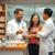 A pharmacist consulting a patient about asthma medication at a modern pharmacy counter with inhalers and prescription bottles visible.