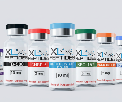 Six labeled vials of XL Peptides, each with a colored cap, stand in a row. Labels show different peptides and dosages, including TB-500, GHRP-6, Bacteriostatic Water, BPC-157, PAMORELIN, IGF-1 LR3, and CJC-1295.